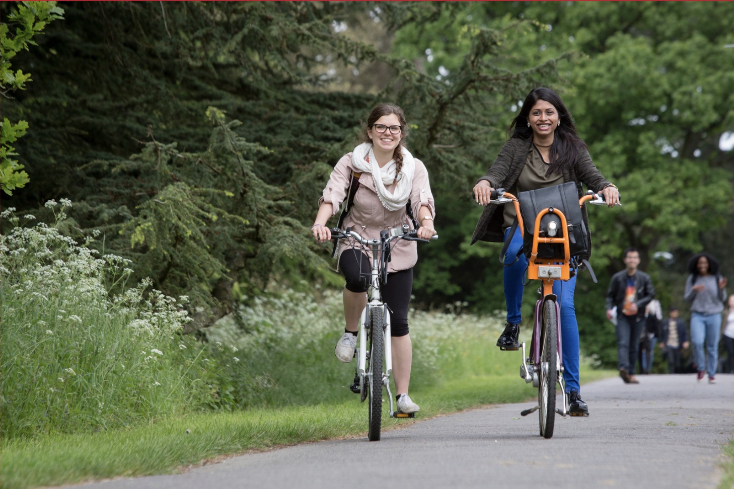 Students cycling through the scenic University of Reading UK campus